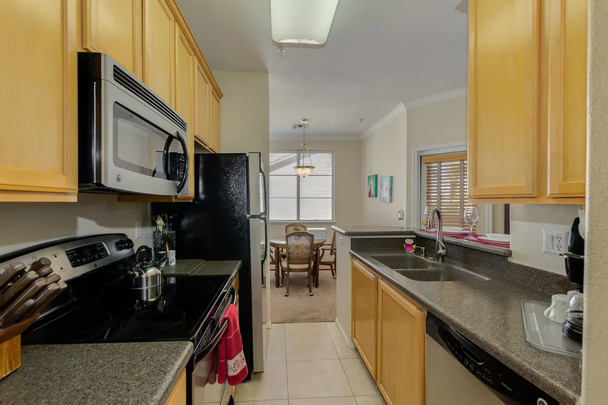 A bright, welcoming kitchen with modern appliances and a spacious countertop opens into the dining area. The space is set up for cooking together or hosting family meals, with plenty of natural light contributing to the inviting atmosphere.